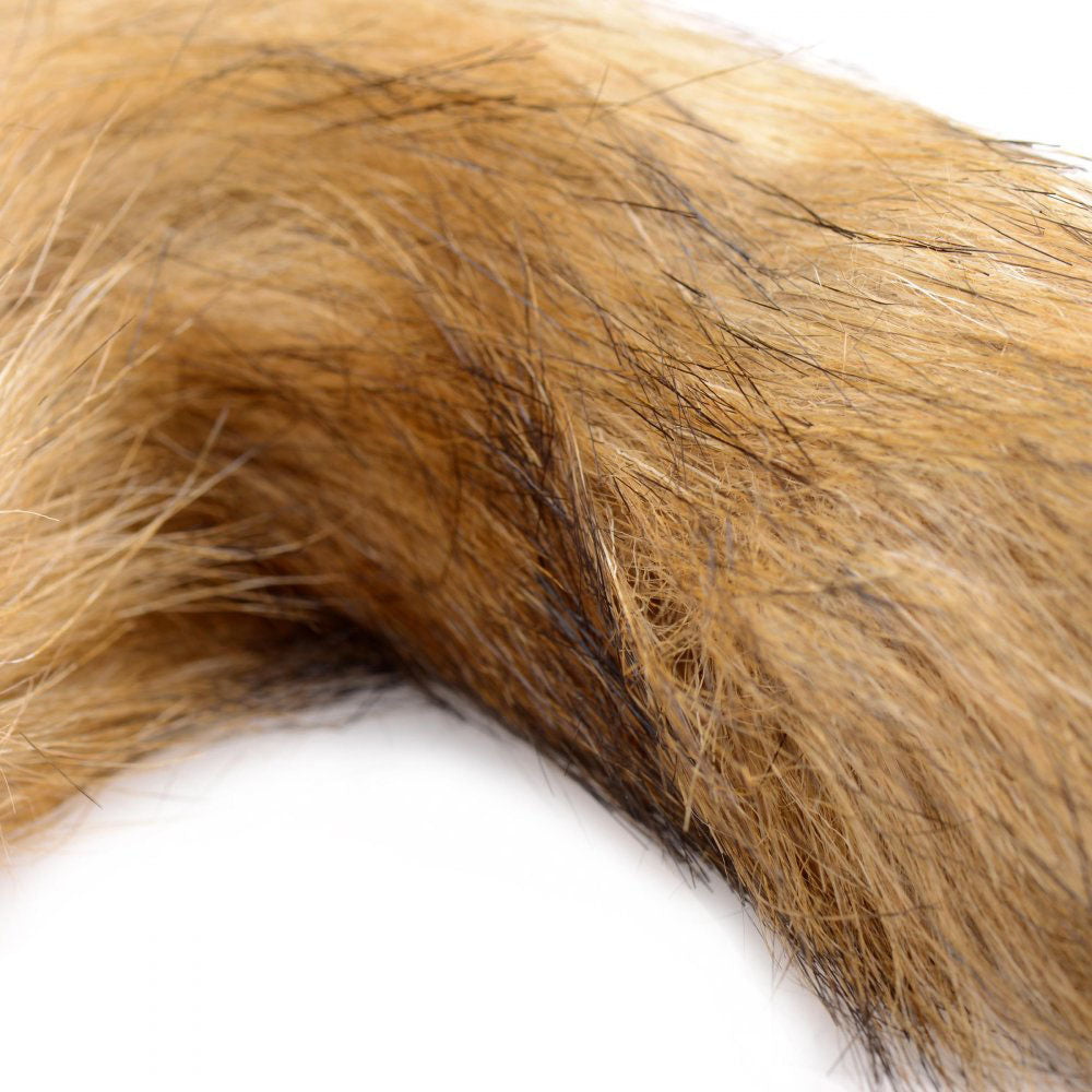 Close-up of the mixed tan and golden-brown faux fur on the bushy fox tail.