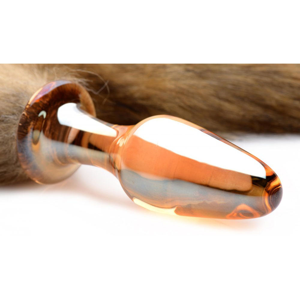 Close-up of the translucent orange glass plug with a rounded tapered tip, narrow neck, and round flared base.