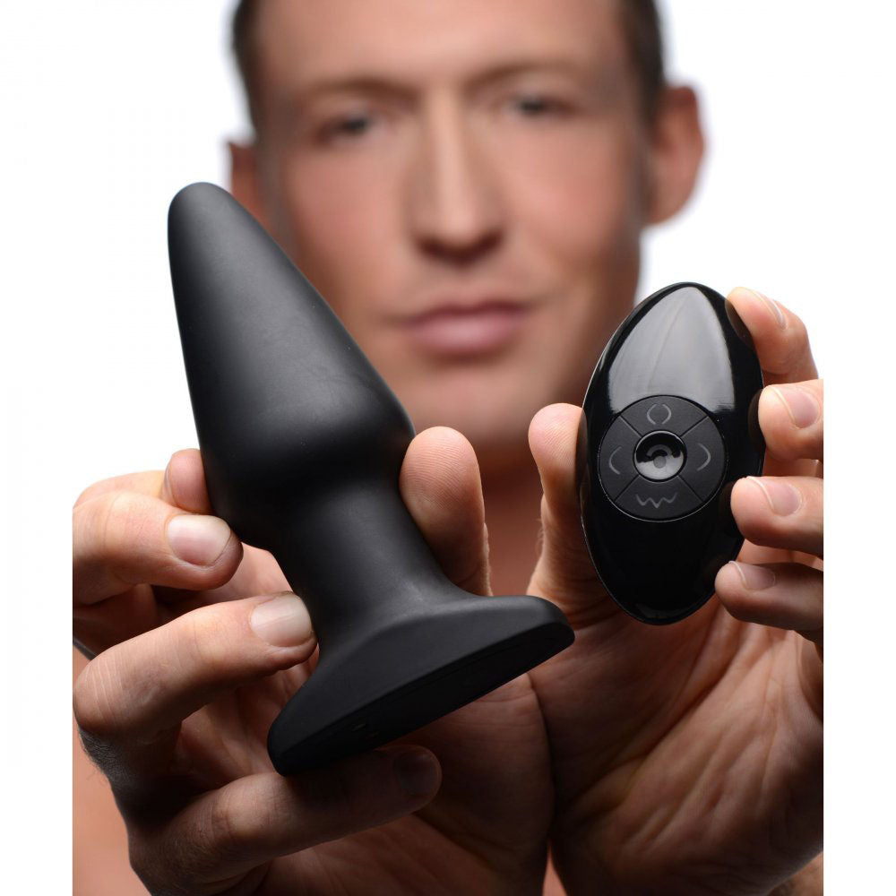 Model holding the broad black rimming plug and oval remote to show relative scale.