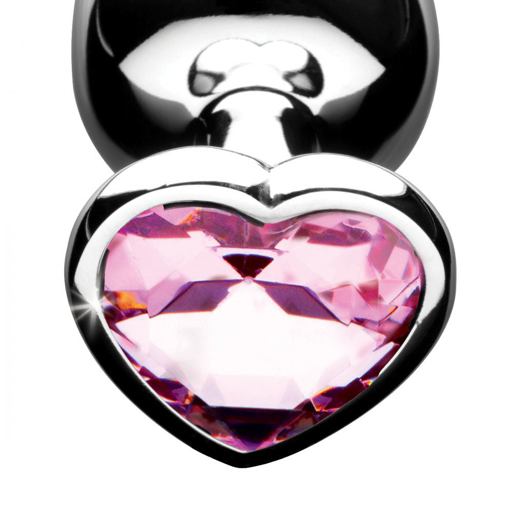 Close-up of a faceted pink heart gem framed by a silver-tone base.