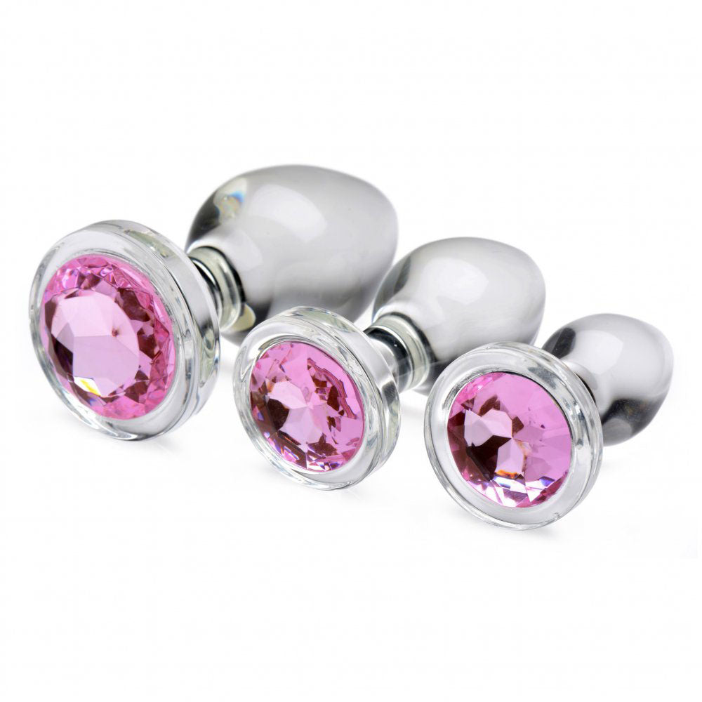 Pink Gem Glass Anal Training Set with three clear graduated plugs lying on their sides to show round faceted bases.