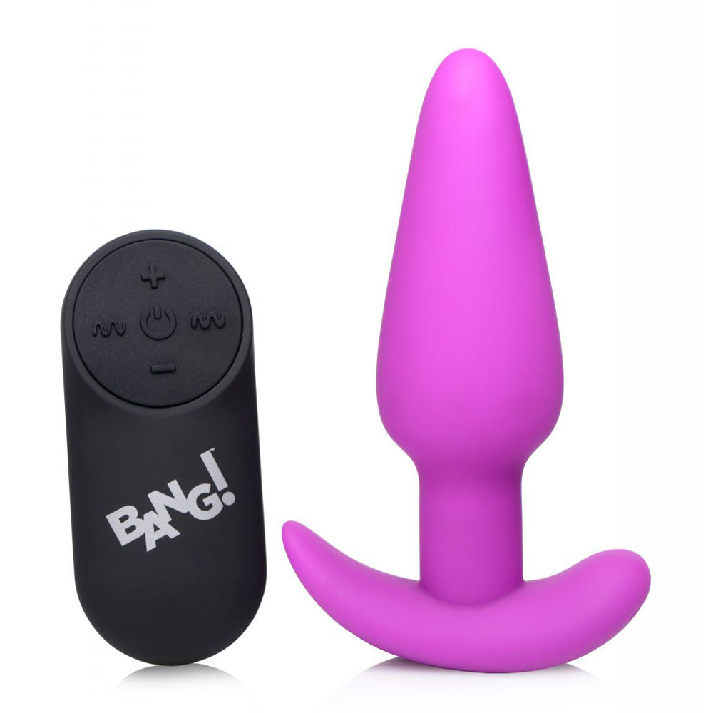 Purple silicone butt plug standing next to the black remote on a white background.