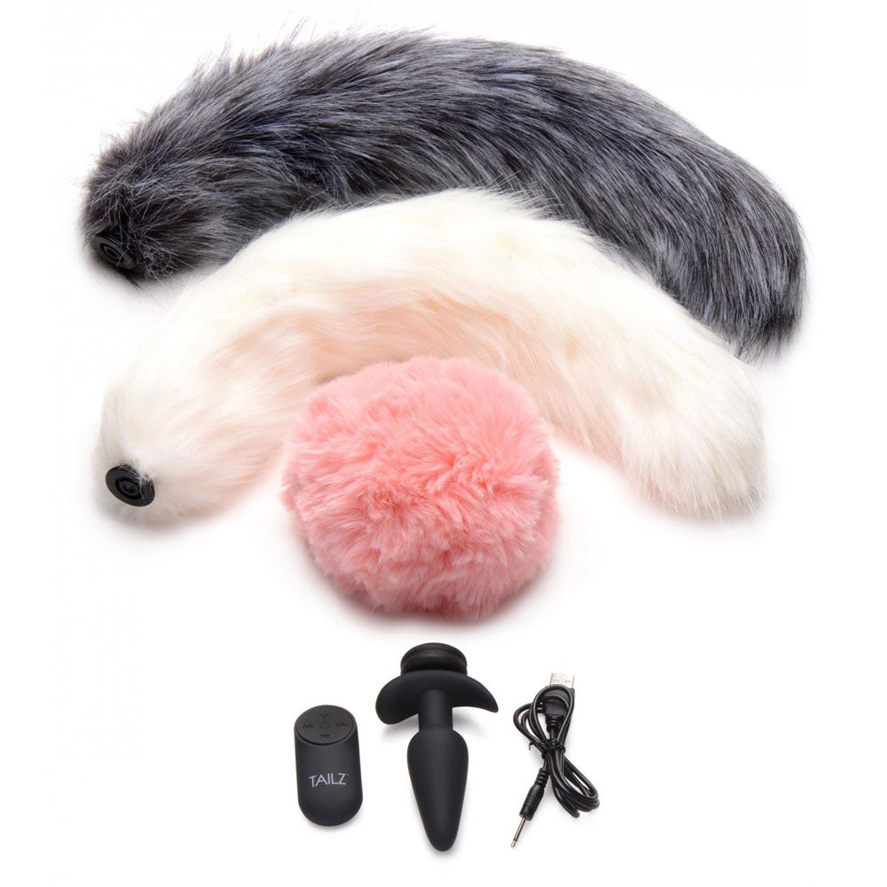 Remote Vibrating Butt Plug Kit With 3 Interchangeable Tails shown with the black plug, controller, charging cable, 2 fox tails, and a bunny tail.