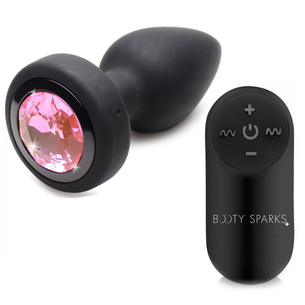 Angled black vibrating butt plug with pink gem top shown beside the handheld remote.