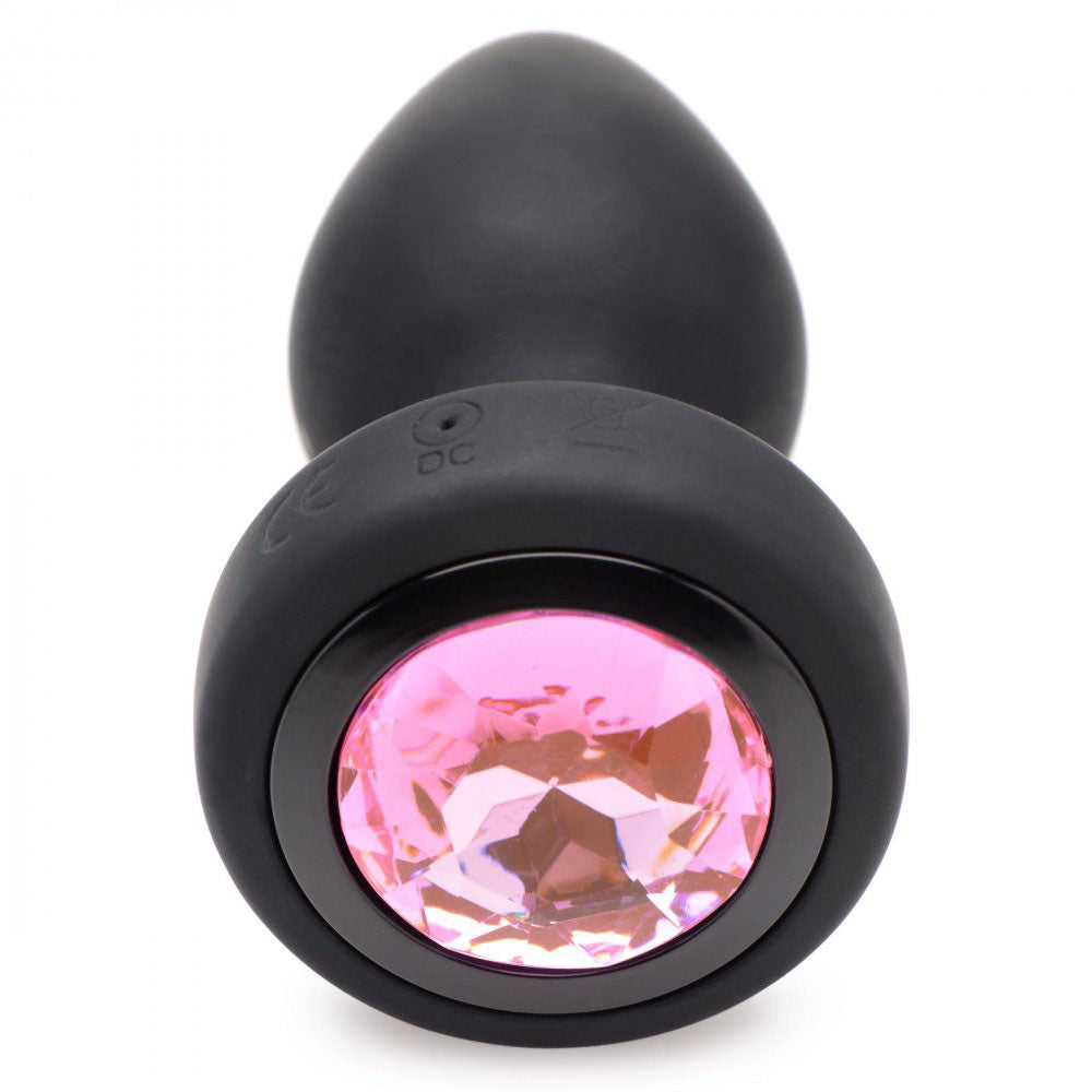 Pink faceted gem top set into the black flared base with the plug body behind it.