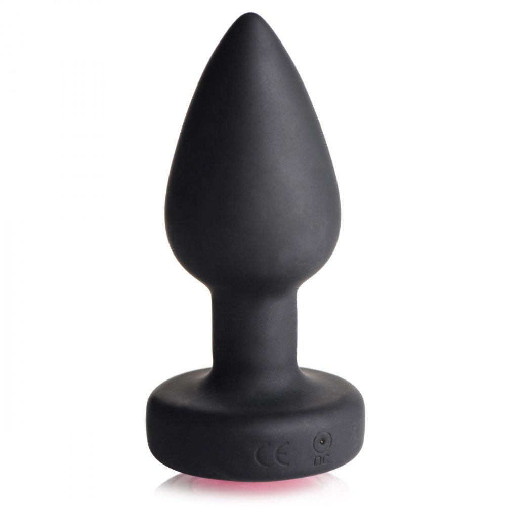 Upright black silicone vibrating plug with tapered tip, narrow neck, flared base, and charging port.