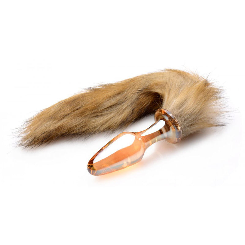 Amber-colored translucent butt plug with a tan and brown furry tail on a white background.