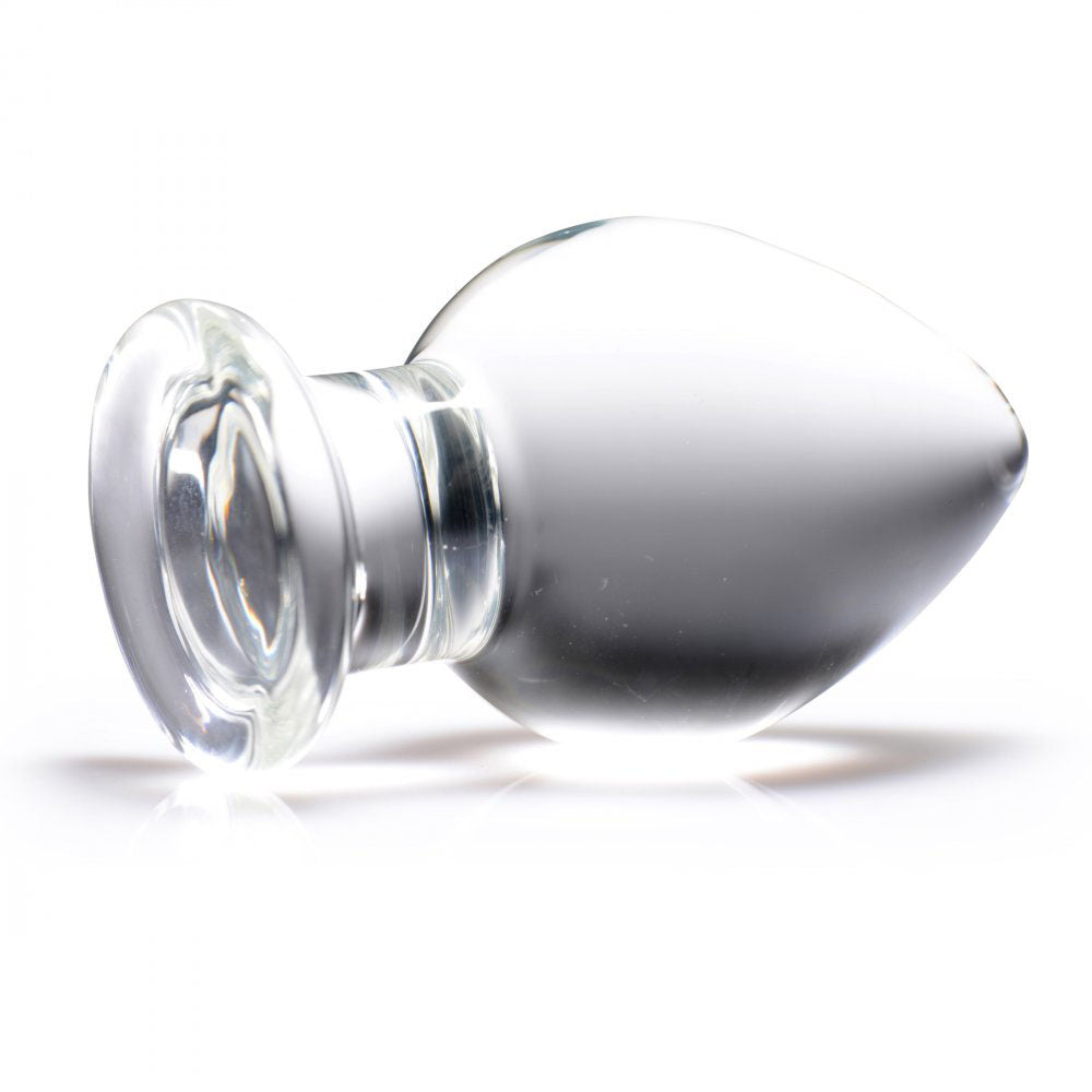 Clear wide glass plug lying on its side with a tapered tip, rounded body, narrow neck, and flared base.