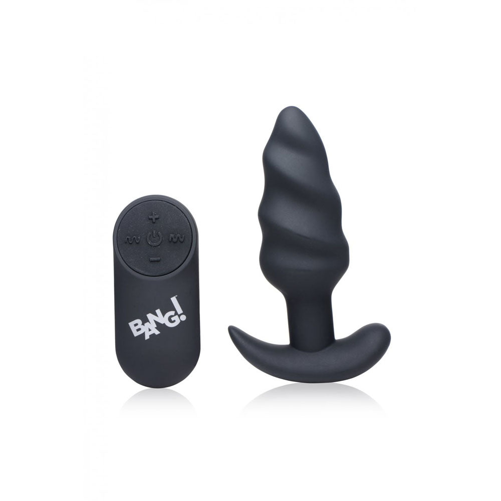 Black twisted butt plug standing beside a black wireless remote with button controls.