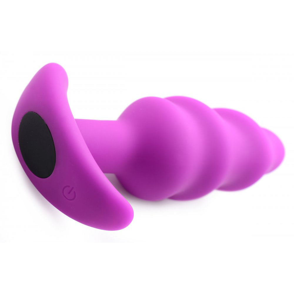 Purple silicone swirl plug lying on its side with flared base and base control button.