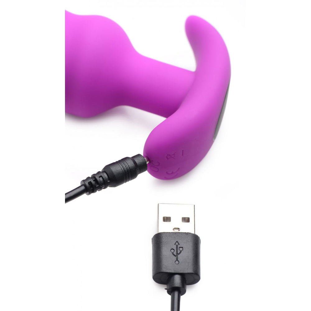 Purple vibrating butt plug with USB charging cable connected to the flared base.