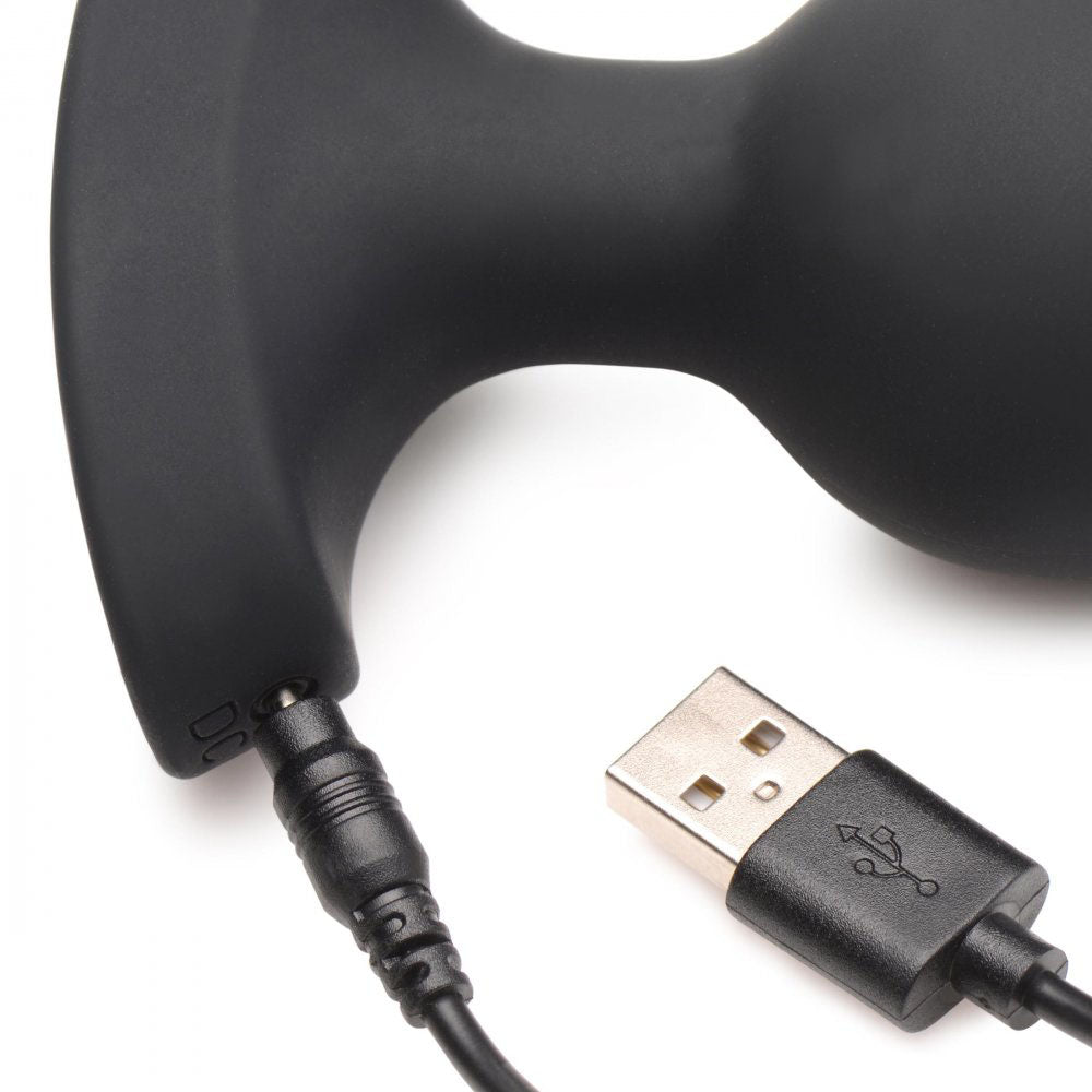 Close-up of the silicone butt plug charging port with USB cable plugged into the flared base